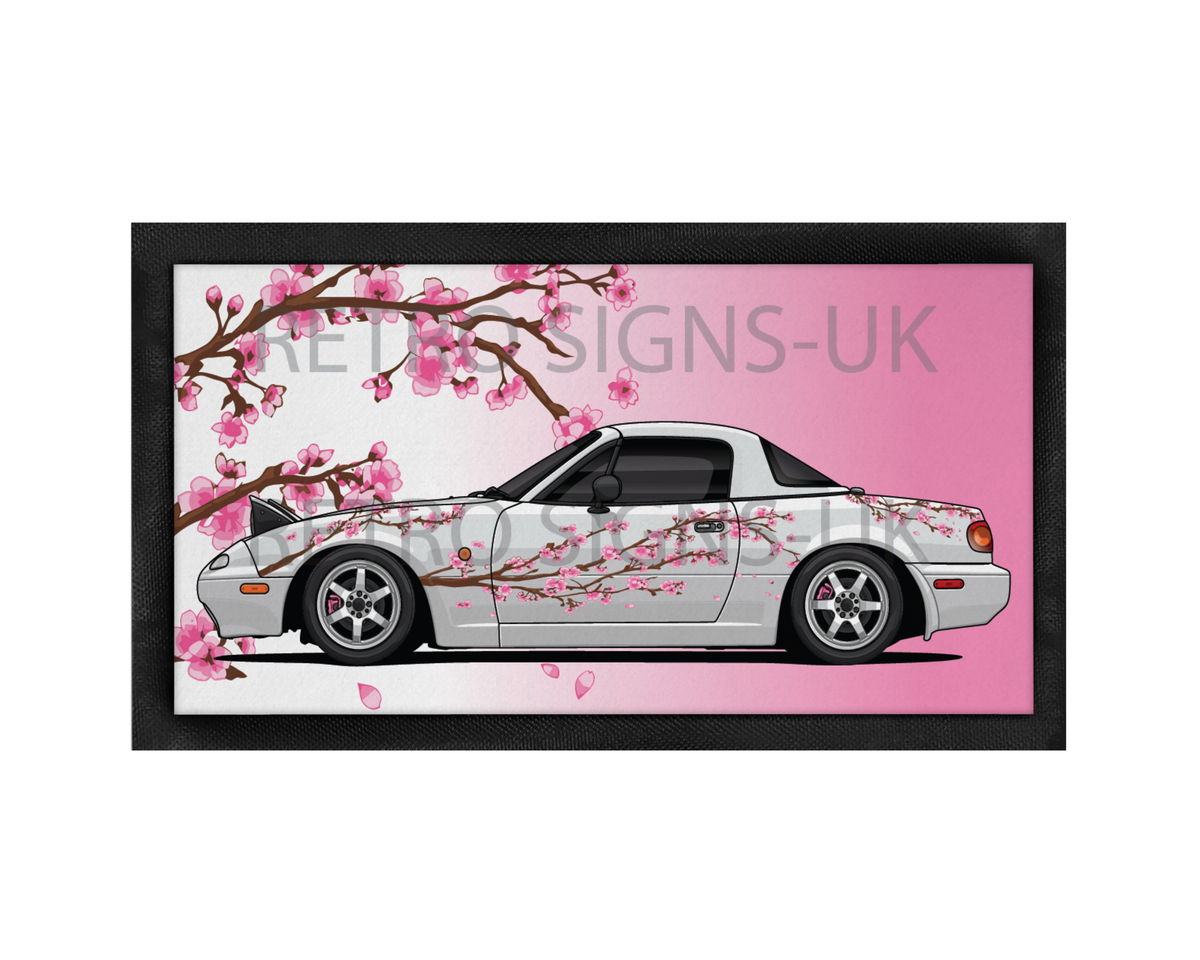 White Mazda MX-5 Mk1 Miata with pink Japanese cherry blossom artwork on a 44cm x 25cm non-slip rubber-backed bar runner.